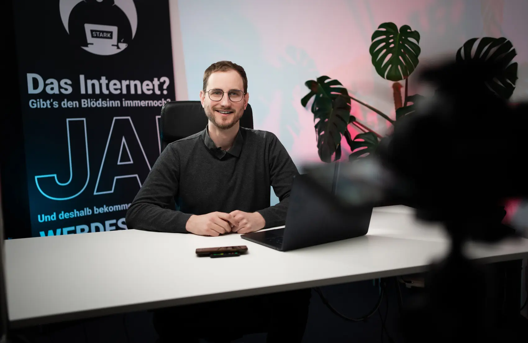 Joshua Stark am Schreibtisch vor einer Kamera
